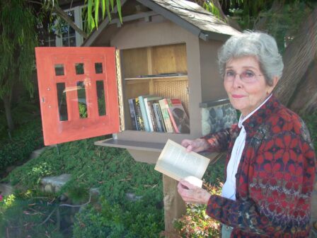 Joan Crone stands next to one of the Free Libraries located in Mission Hills. 