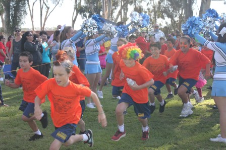 St. Vincent de Paul School students run laps while being cheered on by the Our Lady of Peace Cheerleaders.