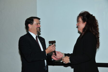 Debbie Rider passes the board of directors gavel to incoming chair Rick Brooks.