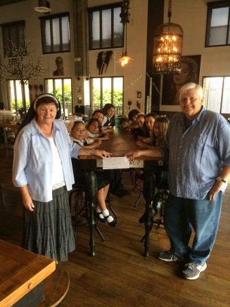 Michael McGeath, Owner of Brooklyn Girl Eatery, presents a check to Sr. Kathleen Walsh, principal of St. Vincent de Paul School. St. Vincent’s students joined in the presentation.