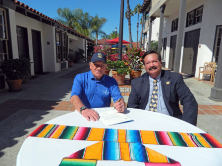 Randy Jones and Fred Grand sign an agreement for a major joint effort between the Randy Jones Golf Invitational and Pacific Hospitality Group to potentially increase fundraising for hundreds of charities countywide.