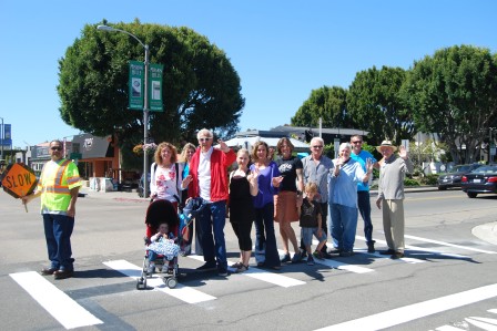 Residents, business owners and guests are the first to use the new crosswalk.  Left to right are Jose Perez, Asher Engle (stroller), Nancy Hubbert, Gerrie Trussell, Larry Hubbert,  Valerie Wilkerson, Cathy Cipriano, Lauren Hodson, Liam Hodson, Doug Yeagley, Michael McGrath, John Bertsch and Tom Curl.